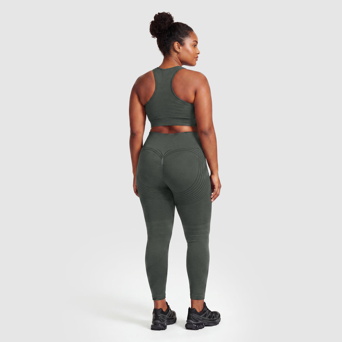 Mujer con leggings anticelulitis Sculpt 3D™ en gris, vista de espalda, glúteos levantados y contorneados