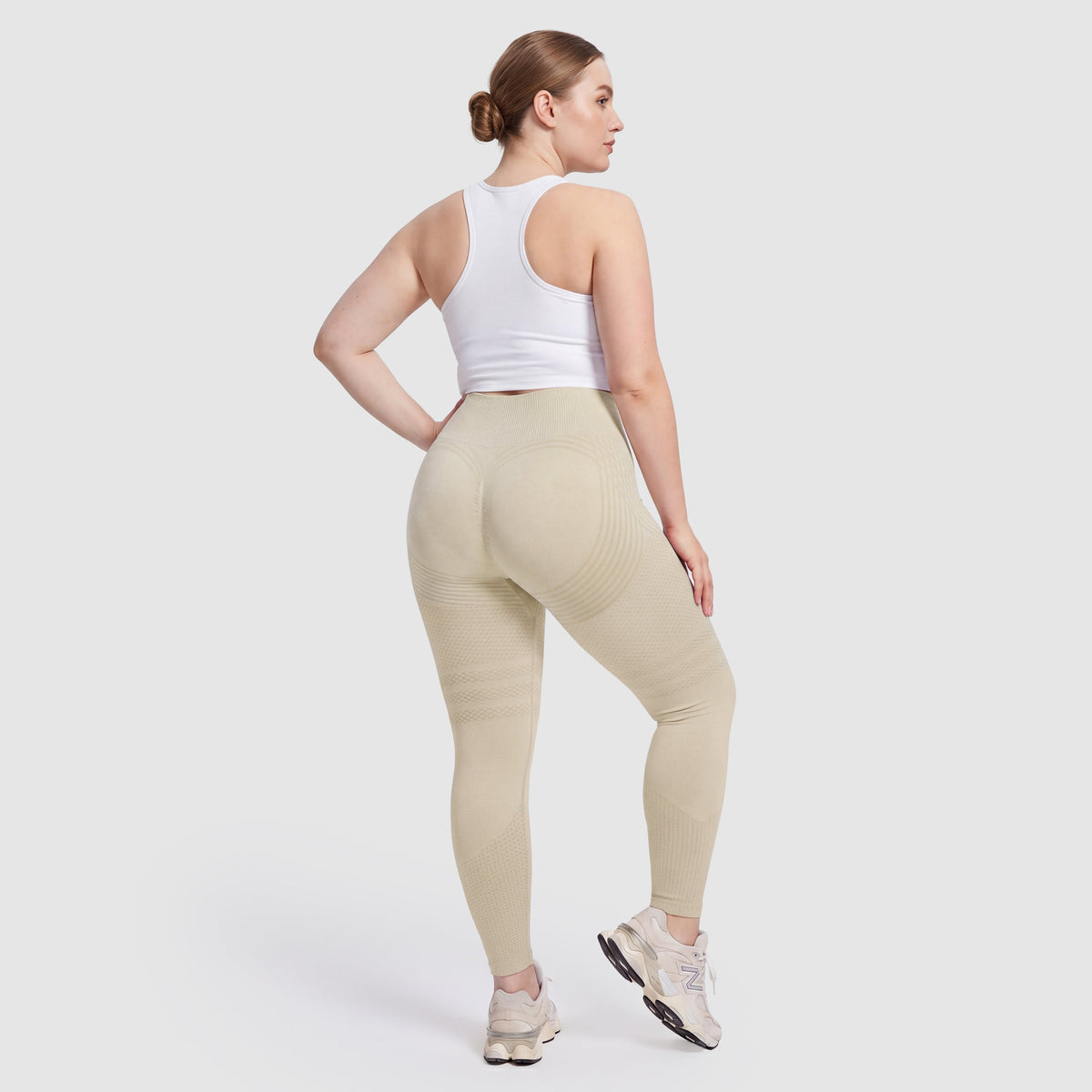 Mujer con leggings anticelulitis Sculpt 3D™ en beige, vista de espalda, glúteos levantados y contorneados